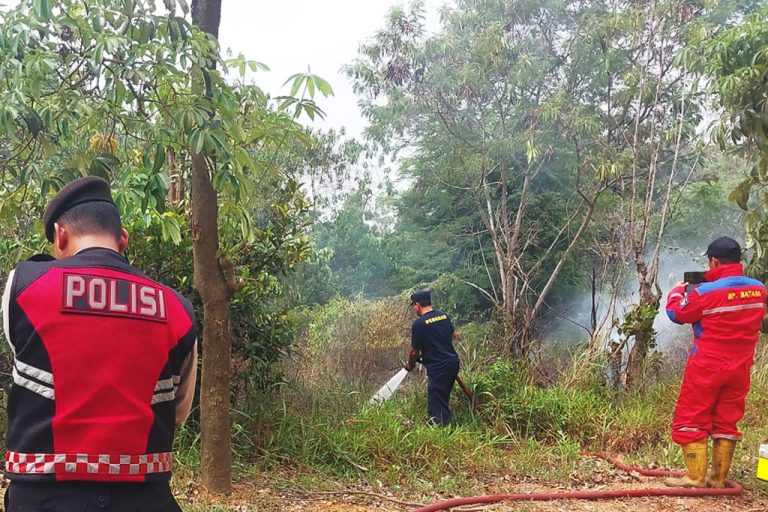 Petugas pemadam kebakaran BP Batam bersama personel Polsek Nongsa memadamkan kebakaran semak belukar di tepi Jalan Sambau, Kecamatan Nongsa, Batam, Kepri, Selasa (15/9/2026)
