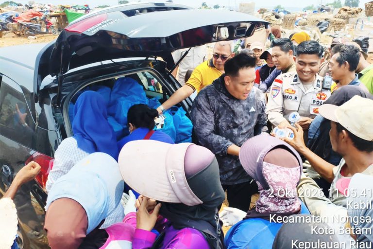 Kapolsek Nongsa AKP Eko Chandra dikerubuti warga saat membagikan nasi kotak Jumat Berkah di TPA Punggur, Jumat (2/10/2026)