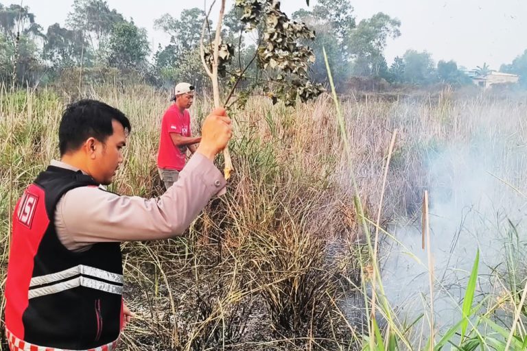 Personel Polsek Nongsa bersama warga memadamkan kebakaran semak belukar di Kampung Jabi, Kelurahan Batu Besar, Kecamatan Nongsa, Batam, Sabtu (3/10/2026)
